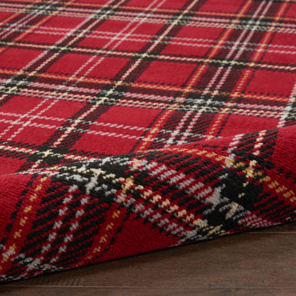 Red plaid rug with black, white and yellow stripes, round 3' diameter, on a dark wood floor with a folded corner.
