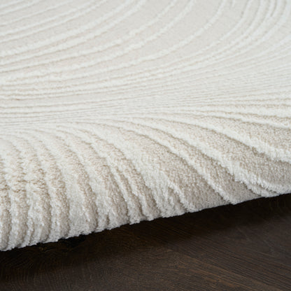 Cream plush rug with ribbed wave texture on dark wood floor.