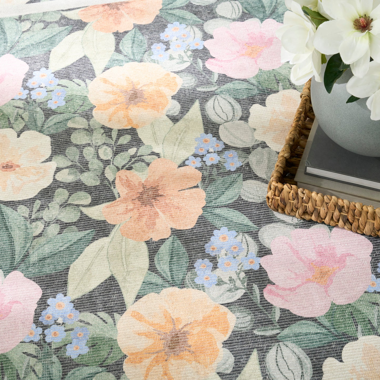 Pastel floral pattern with peach, pink and blue blossoms and green leaves; woven basket with white flowers.