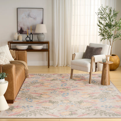 Cozy contemporary living room with a pastel floral rug, tan leather sofa, white armchair, wooden console table and tall plant.
