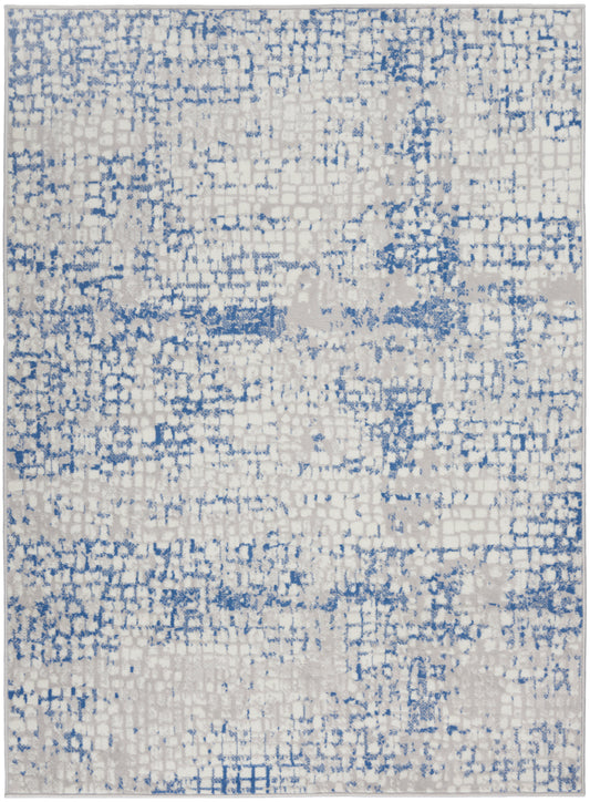 Rectangular area rug with cream base and blue distressed pixel pattern; modern abstract rug.