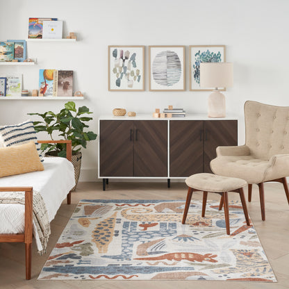 Bright mid-century living room with dark wood cabinet, beige armchair and ottoman, abstract rug, plant and wall art.
