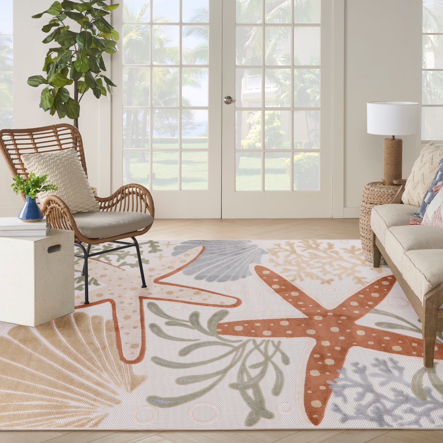 Outdoor rug with a bright nautical design featuring orange starfish and seaweed.