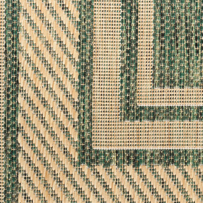 Geometric woven rug close-up in cream and forest green with diagonal stripes and nested border motif.