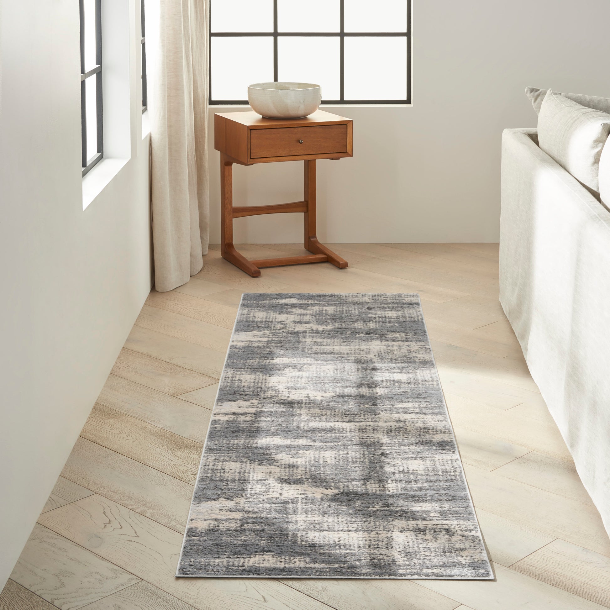 Gray abstract runner rug on a bright living room floor, 7' long.