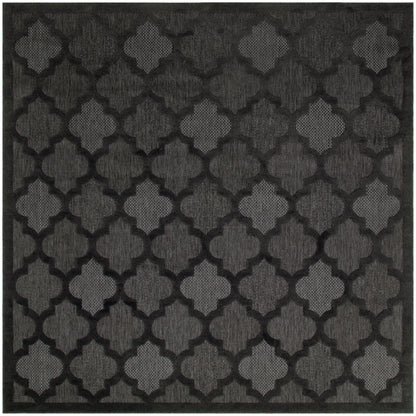 Charcoal-black square rug with a repeating quatrefoil lattice pattern and textured weave.