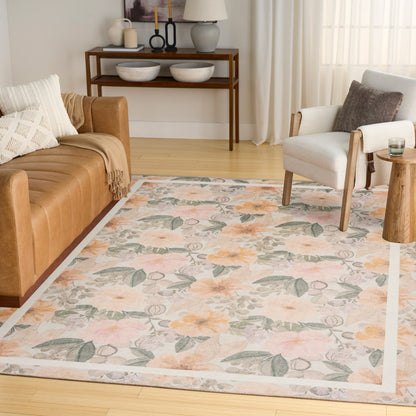 Soft woven floral area rug in peach and gray-green tones on a light background, in a modern living room.