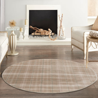 Round beige plaid area rug for a neutral living room with cream furniture and a fireplace.