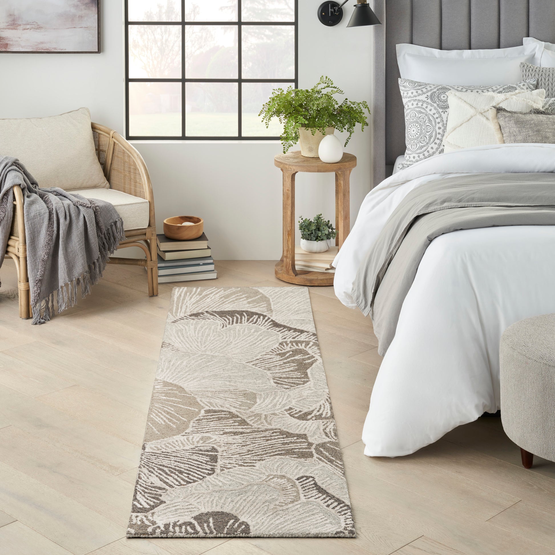 Beige palm-leaf flatweave rug runner in a cozy farmhouse bedroom with light wood floors and white bedding.