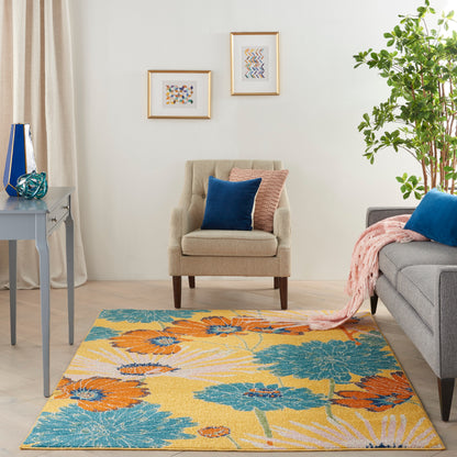 Cozy living room with a vibrant yellow floral rug in teal and orange, beige armchair, gray sofa, blue and pink cushions.