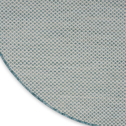 Round blue and white woven rug with a small diamond lattice pattern and teal edge.