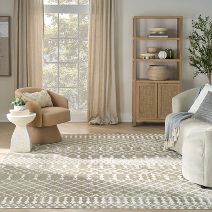 Neutral living room with beige lounge chair, white side table, light wood bookshelf, woven baskets, and a geometric gray rug.