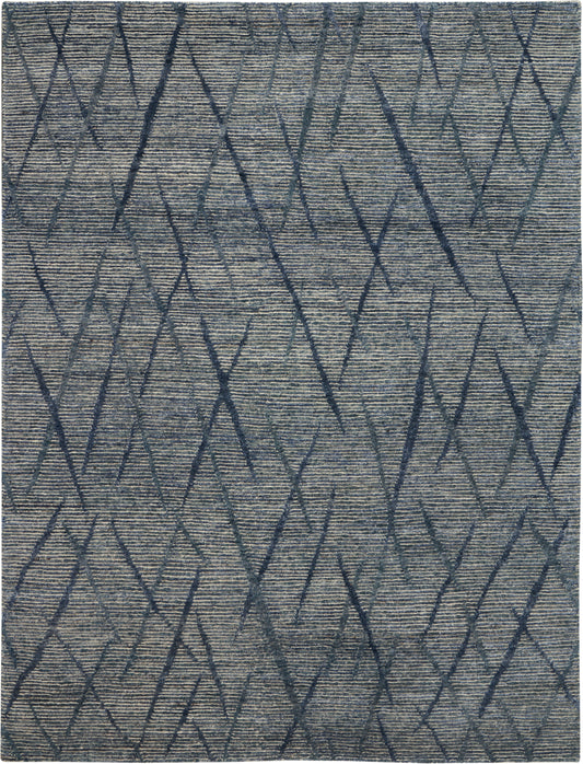 Blue-gray rug with dark navy geometric diamonds on a textured woven surface.