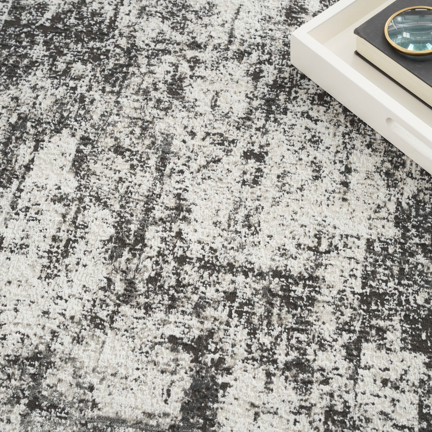 Abstract distressed area rug in black, gray and ivory with a plush, modern look.