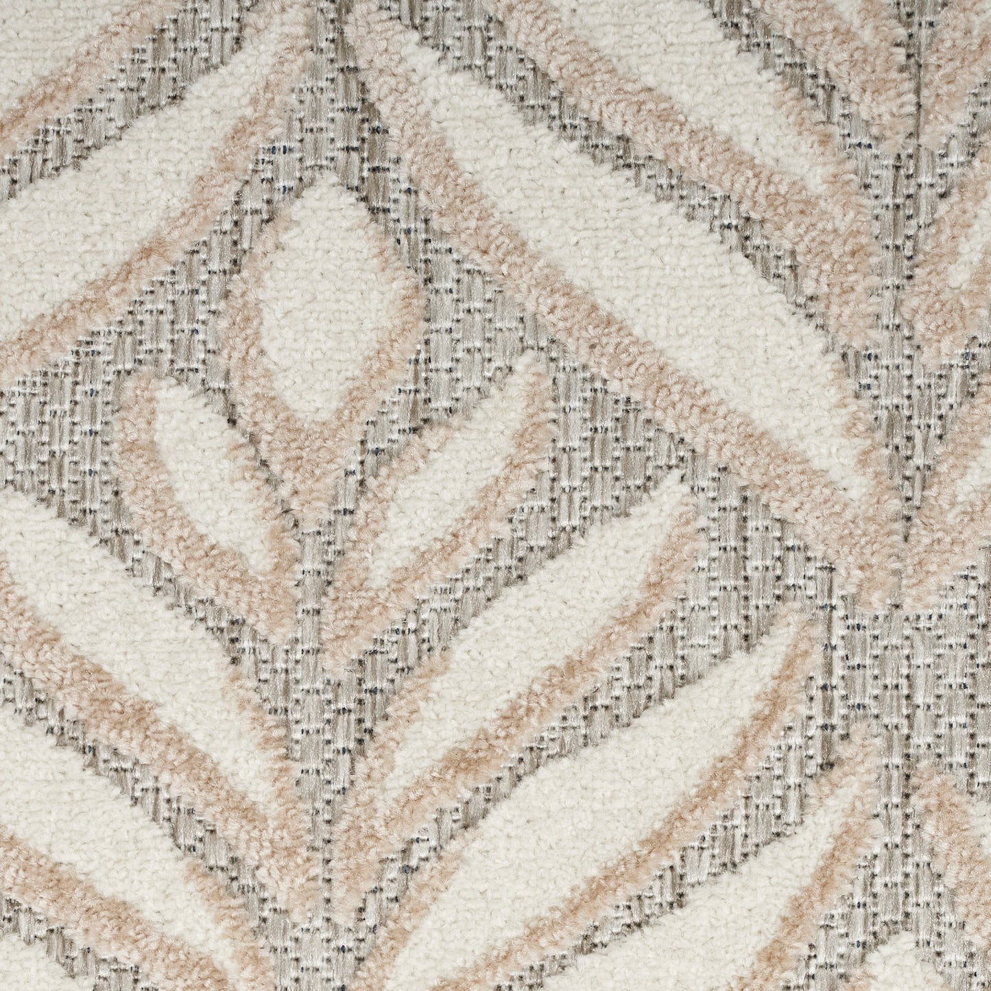 Soft tufted round shag rug with cream and beige chevron leaf pattern on gray ground; plush, modern boho-style decor.