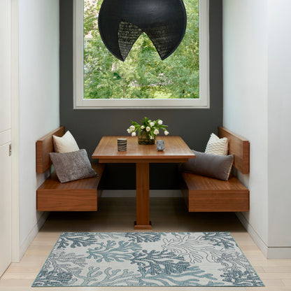 Blue botanical area rug on the floor in a room with a window.