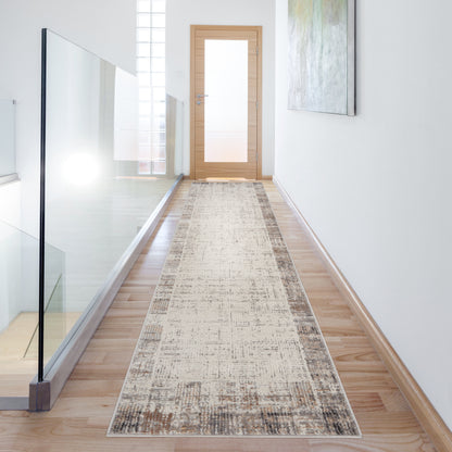 Long beige distressed rug runner along a wood-floor hallway with glass railing and a wooden door at the end.