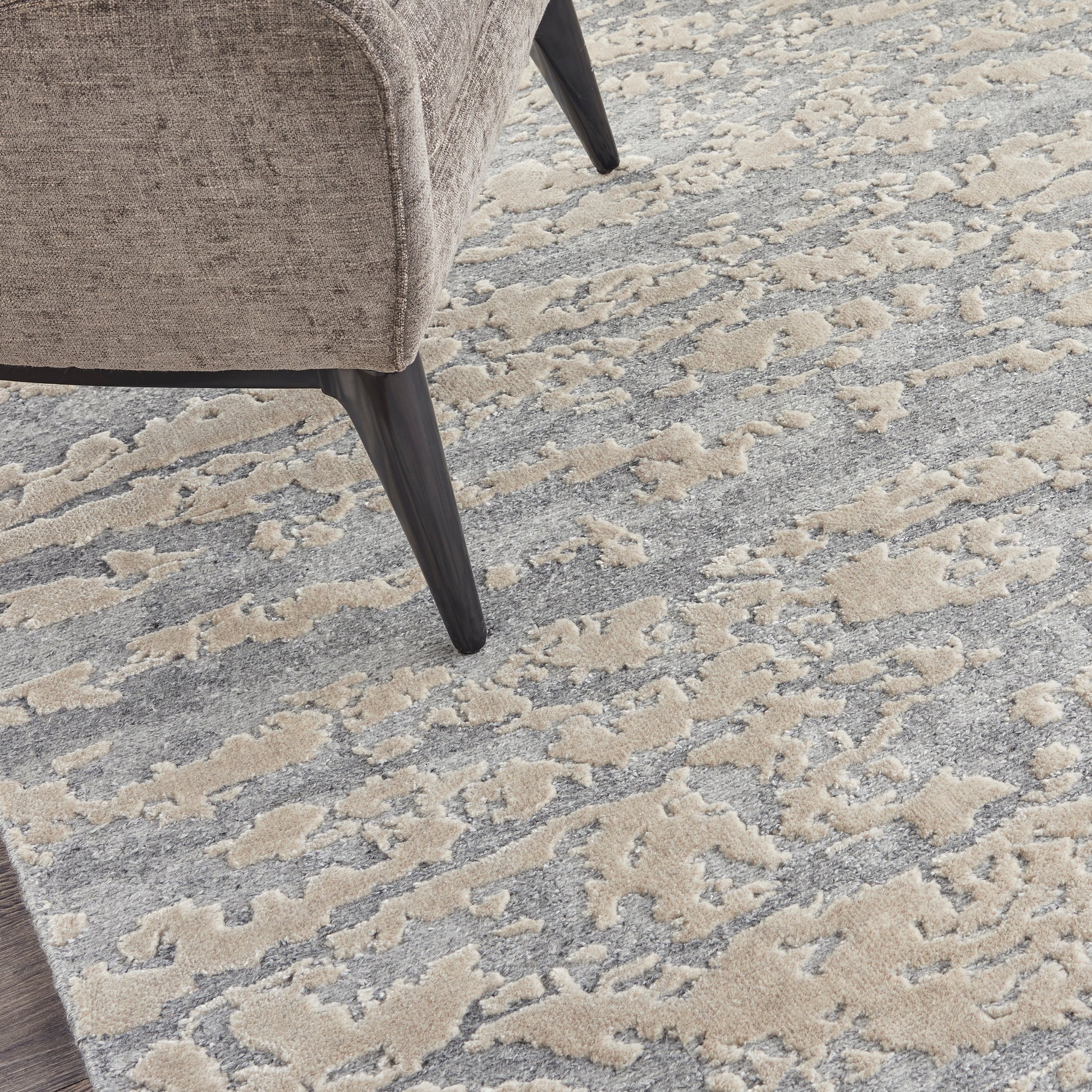 Beige textured rug with an abstract gray-beige pattern.