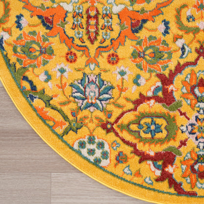 Round yellow oriental rug with colorful floral motif and gold border on wood floor.