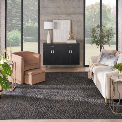 Elegant living room with black sideboard, beige lounge chair, cream sofa, dark patterned rug, gold accents, large windows.