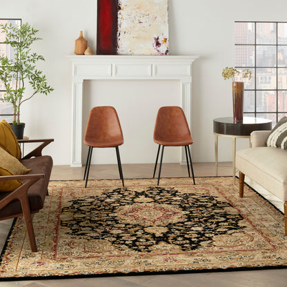 Cozy living room with white fireplace, mid-century chairs, ornate area rug, beige sofa, plant and abstract art.