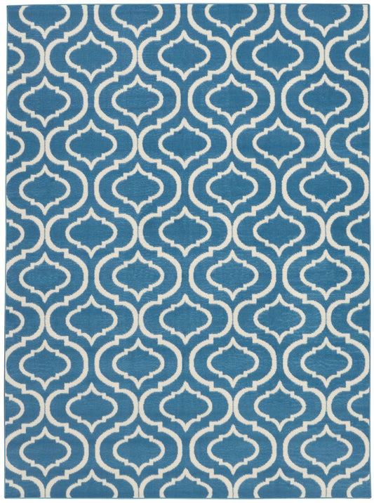 Blue rug with white interlocking quatrefoil lattice pattern; bold geometric, modern coastal style.