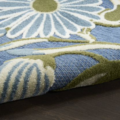 Close-up of blue floral rug with white petals and green stems on dark wood floor.