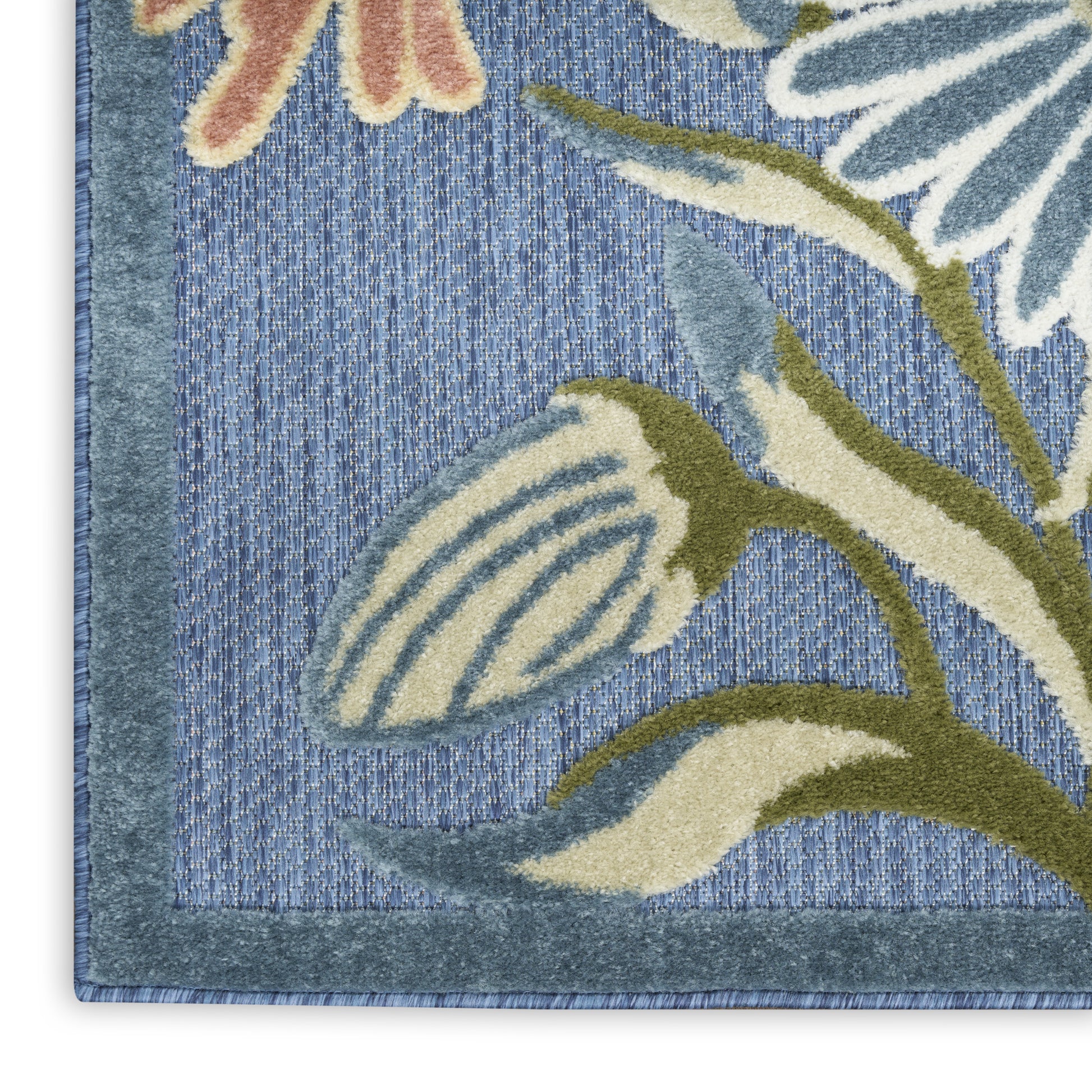Close-up of blue floral rug corner with cream and olive leaves on a denim-blue background and blue border.