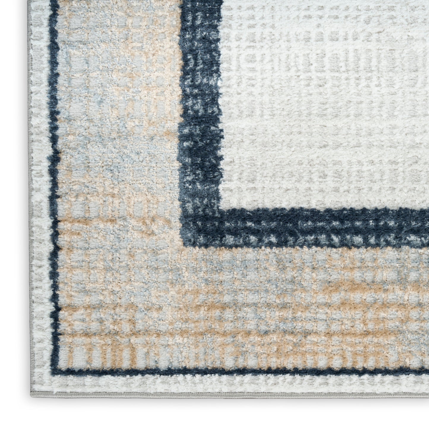 Textured beige and cream rectangular rug with navy border and pale blue inner panels; plush loop pile.