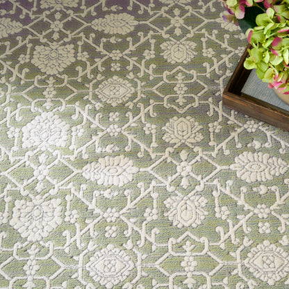 Green rug with cream raised floral lattice pattern; wooden tray corner with pink-green hydrangeas.