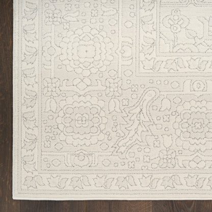 Cream ivory rug with ornate floral border and medallion-inspired central design on dark wood floor.