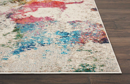Cream abstract rug with vibrant multicolor splashes and white border on dark wood floor.