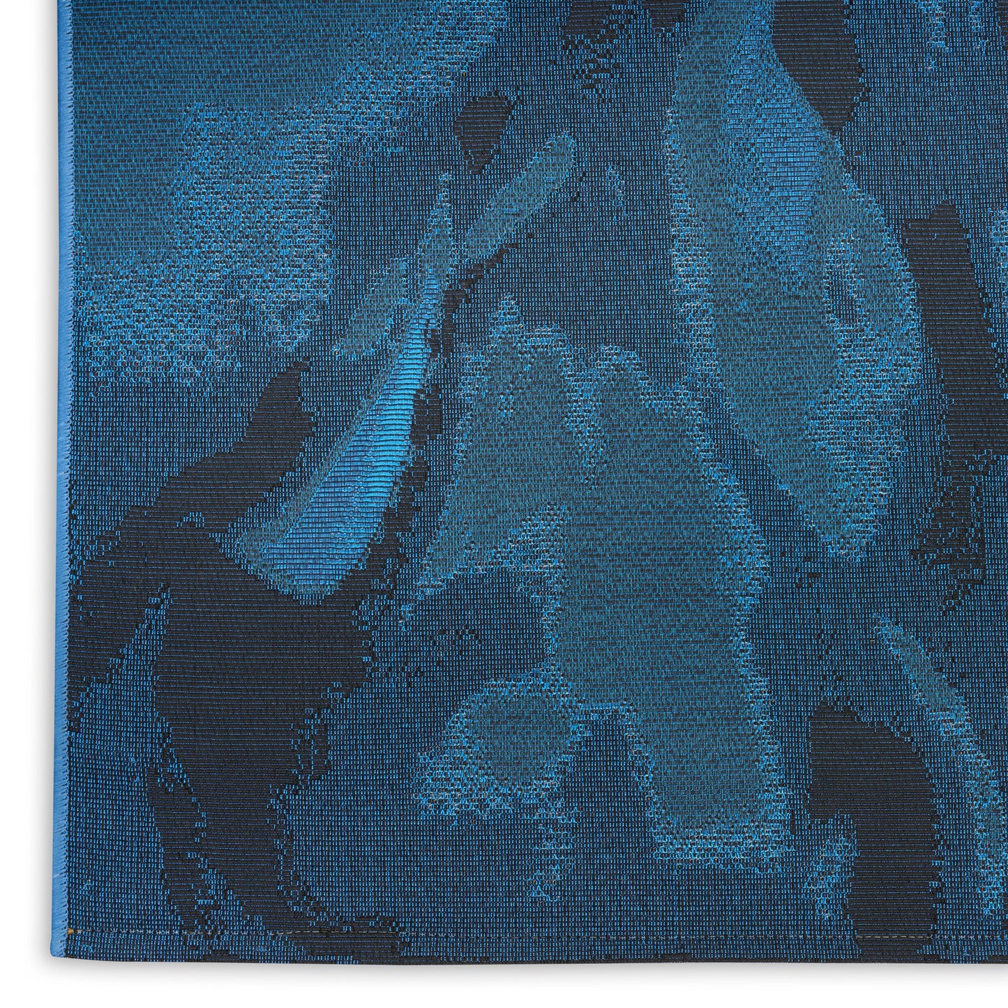 Blue jacquard rug with abstract dark navy floral shapes on teal-blue, textured woven fabric.