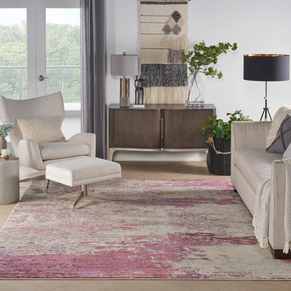 Neutral living room with beige sofa and ottoman, pink distressed rug, dark wood sideboard, plants and modern lamps.