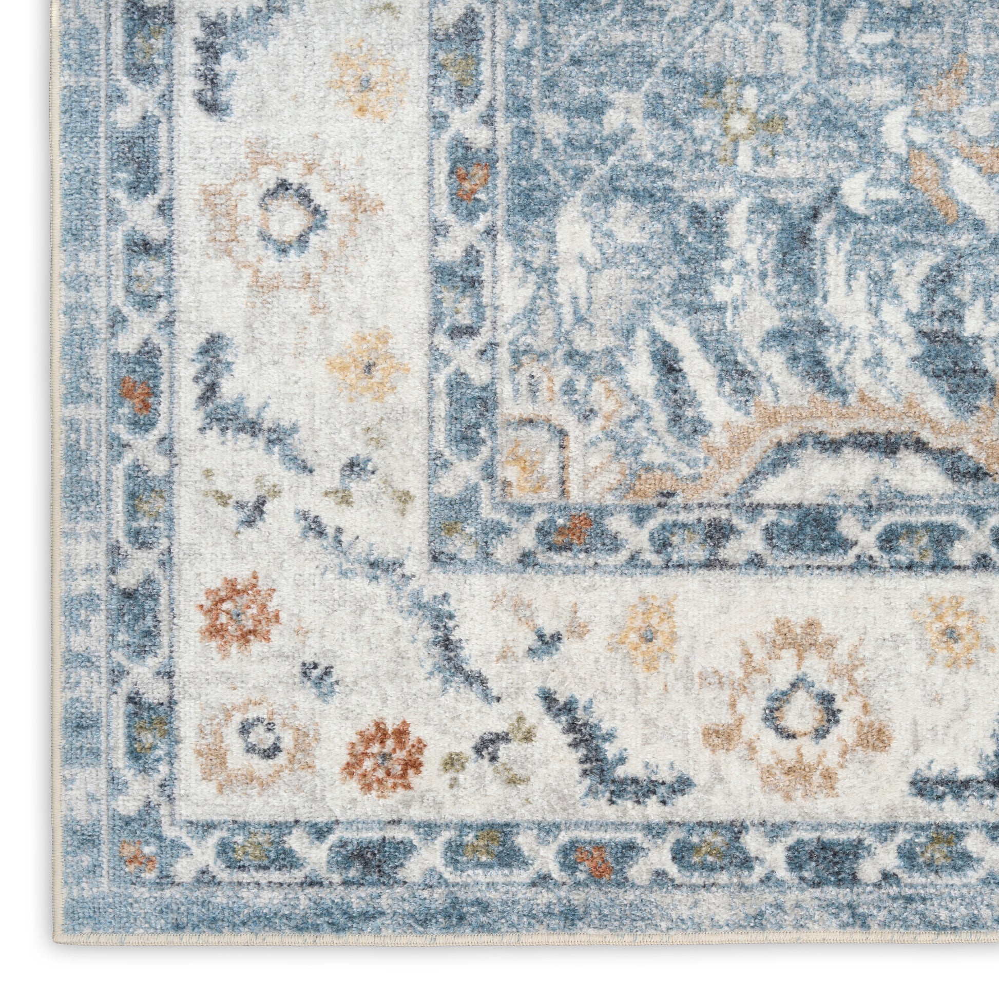 Close-up corner of blue & ivory oriental rug with floral border & distressed pattern.