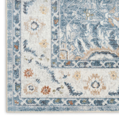 Close-up corner of blue & ivory oriental rug with floral border & distressed pattern.