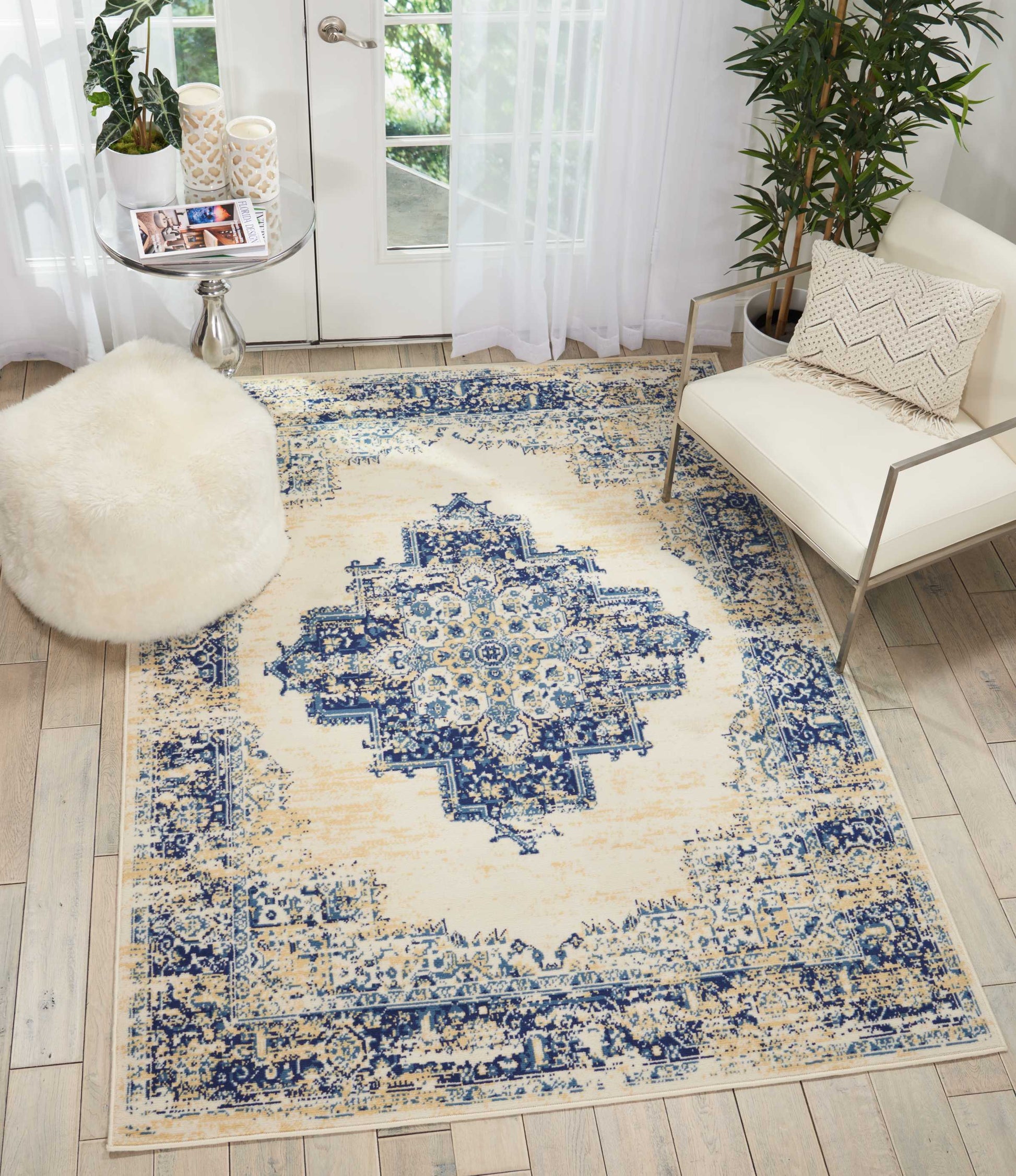Distressed ivory and navy Persian-style area rug with central medallion, blue ornate border, in a modern living room.