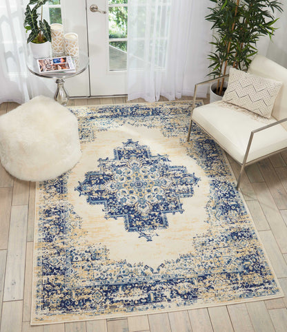 Distressed ivory and navy Persian-style area rug with central medallion, blue ornate border, in a modern living room.