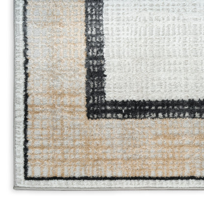 Close-up of a tufted modern geometric area rug in beige, ivory and gray with a black border.