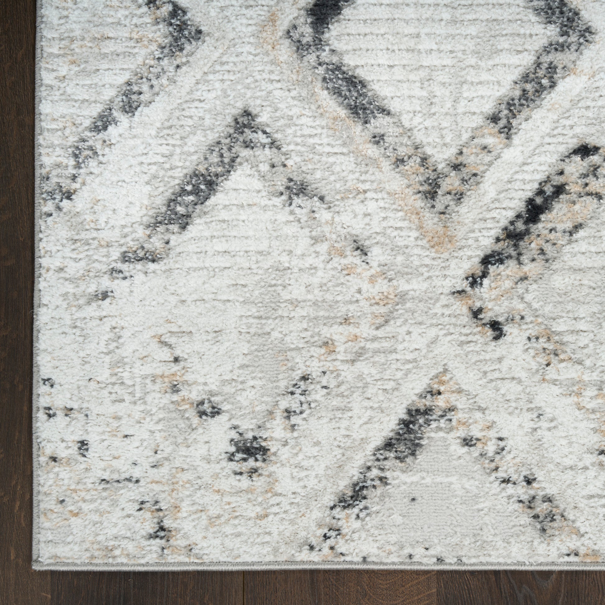Cream geometric rug with gray and beige diamond motif; soft textured pile for living room decor.