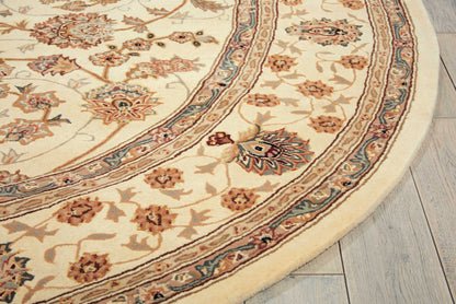 Cream round Persian-style rug with beige and rust florals and decorative border on light wood floor.