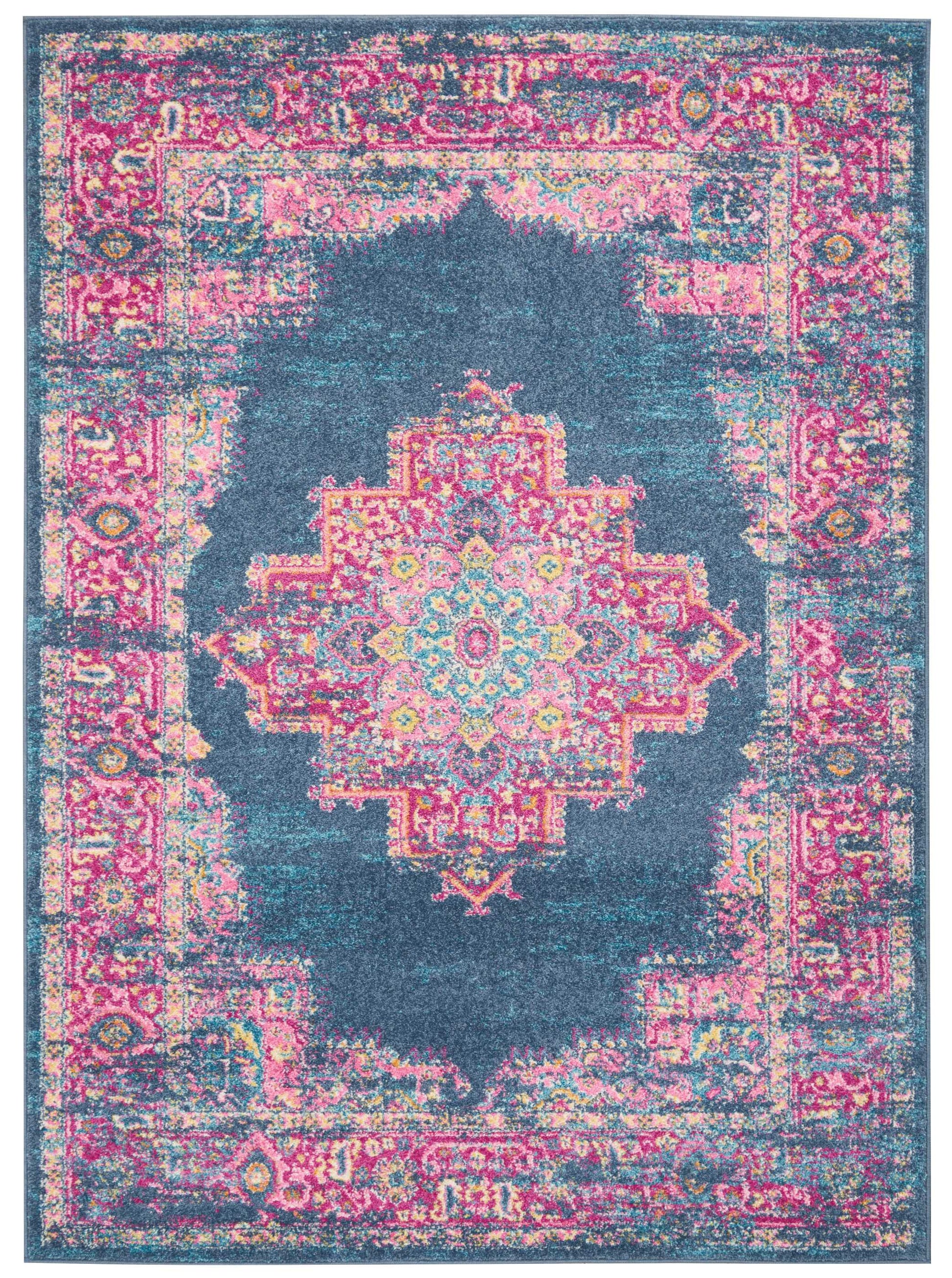 Distressed vintage-style rug with deep blue field, pink patterned border, and multicolor central medallion.