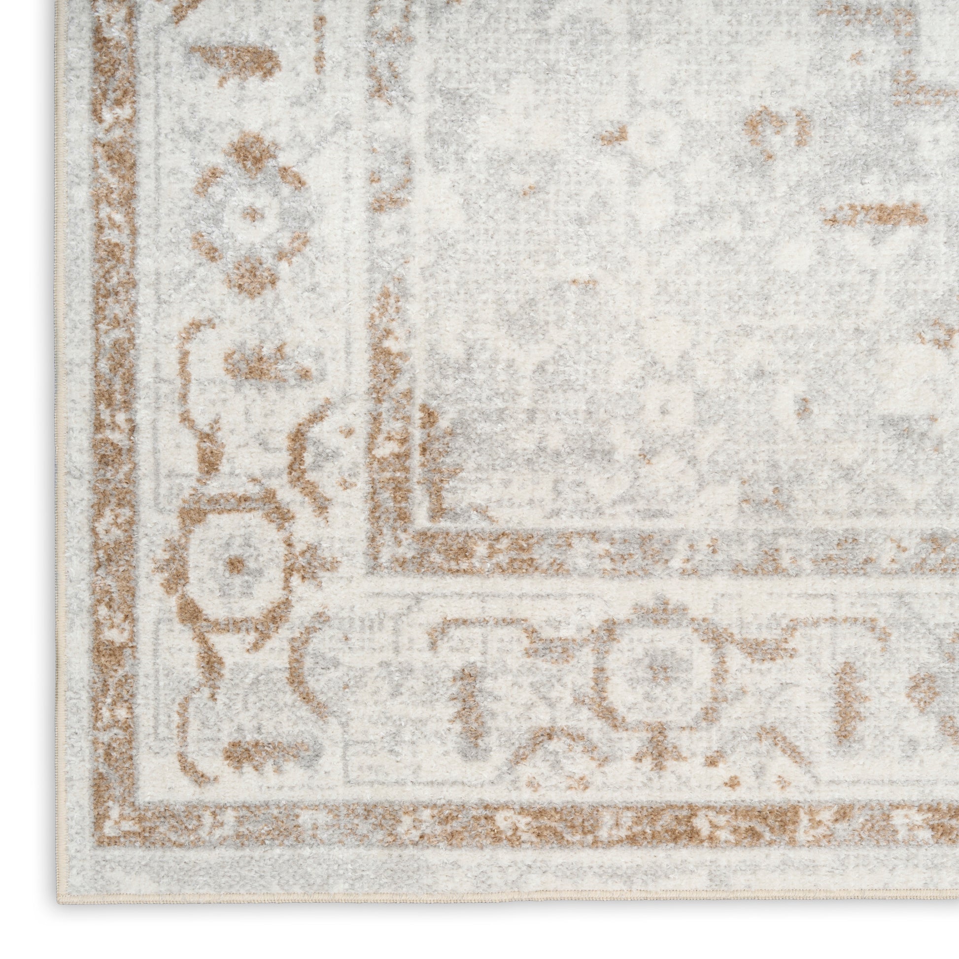 Cream and light grey area rug with brown ornate border and floral motifs, corner view.