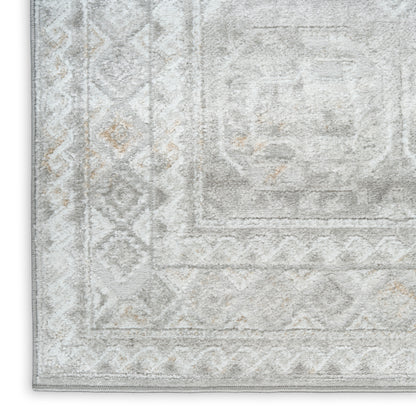 Light gray distressed area rug with faded central medallion, diamond border and subtle beige accents.