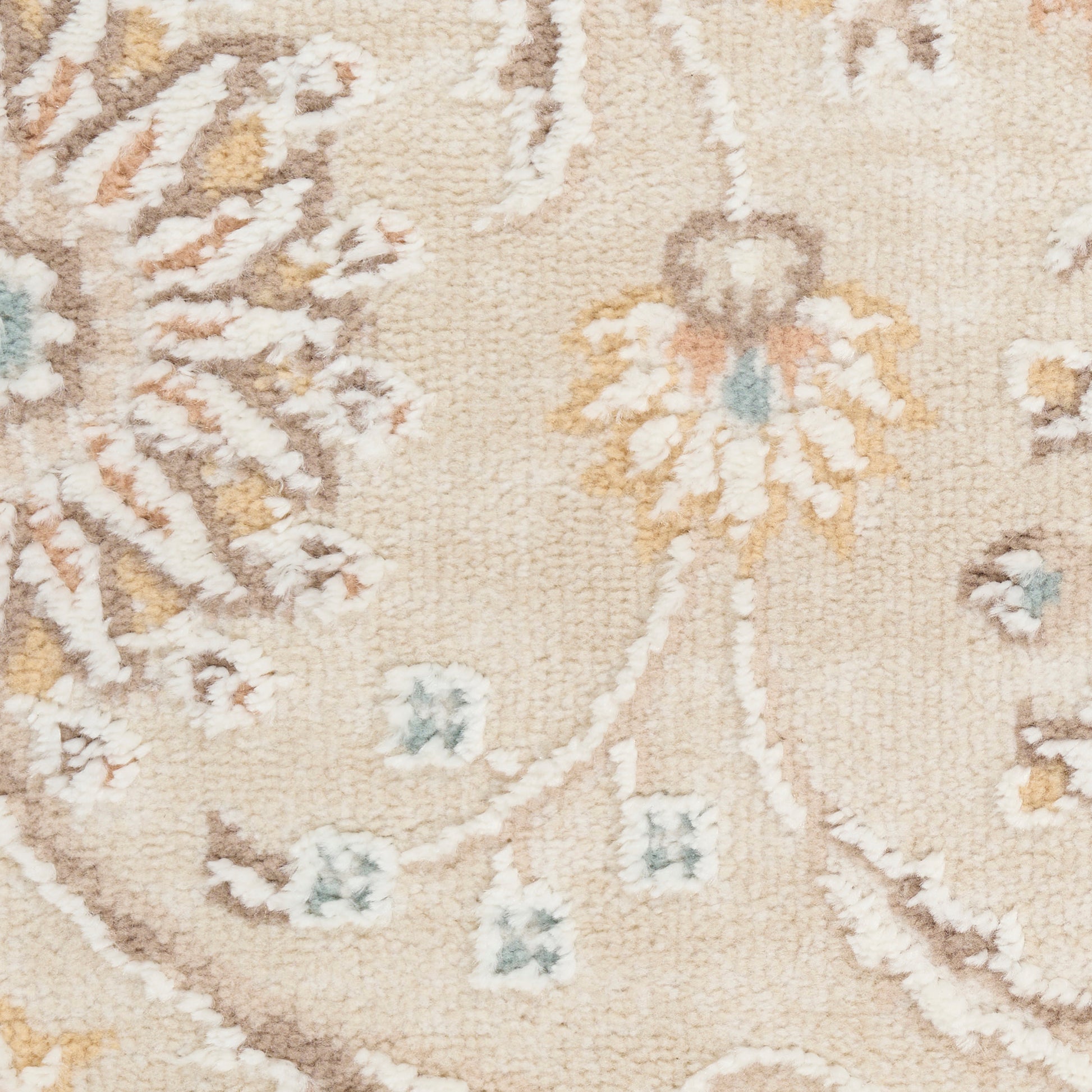 Beige floral-pattern rug close-up with cream, pale blue and orange flowers on a textured woven pile.