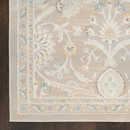 Rectangular beige rug with blue floral vines and pale yellow accents; traditional border, on dark wood floor.