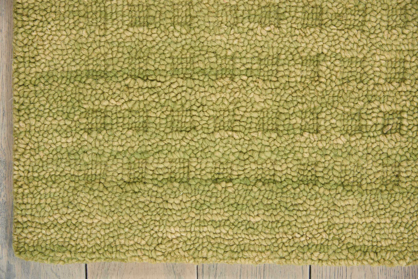 Olive green rectangular shag rug with dense plush pile, shown on a wooden floor.