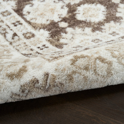 Cream and tan plush area rug with brown oriental-inspired pattern, thick shag pile on dark wood floor