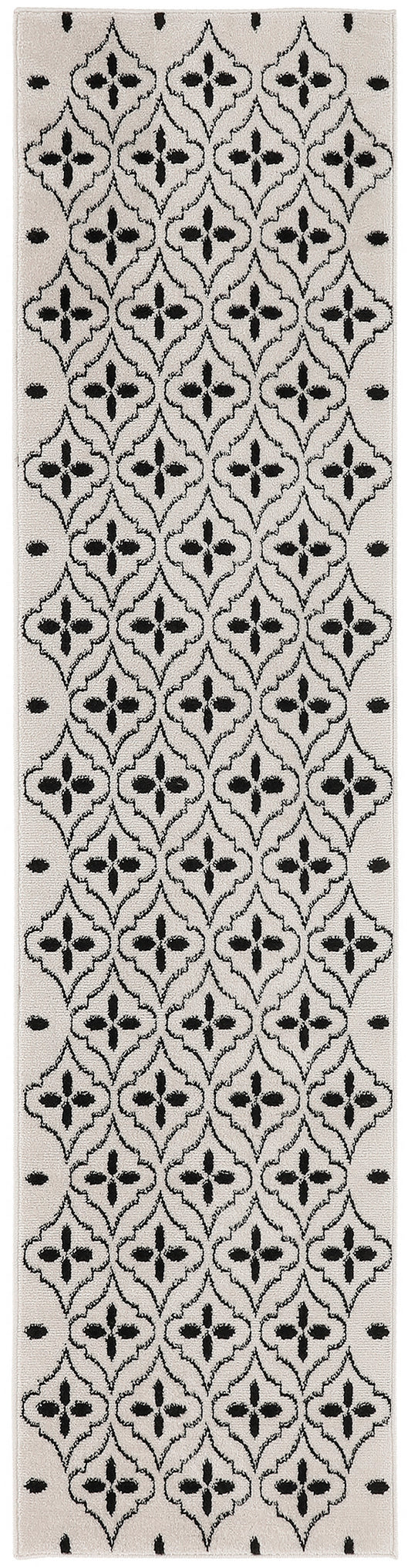Beige runner rug with black lattice-quatrefoil motif and small border dots.
