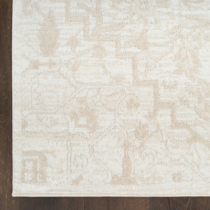 Cream-colored patterned area rug with subtle geometric motifs on dark wood floor.
